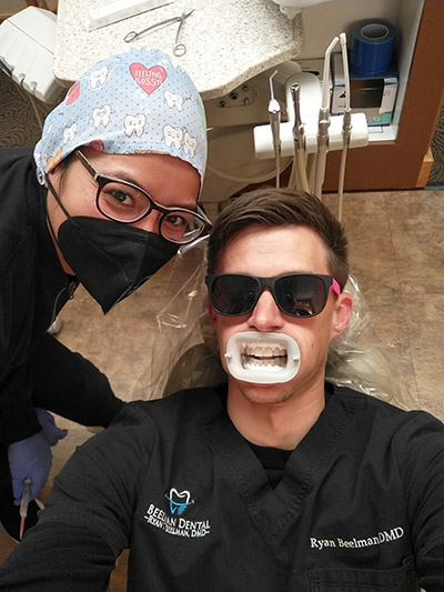 Dr. Beelman laying in the dental chair receiving smile makeover treatments from his staff