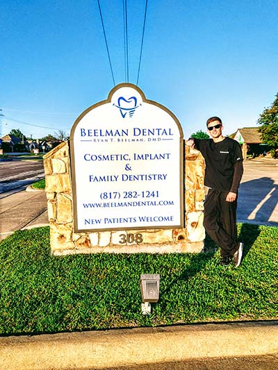 Dr. Beelman standing by the Beelman Dental sign