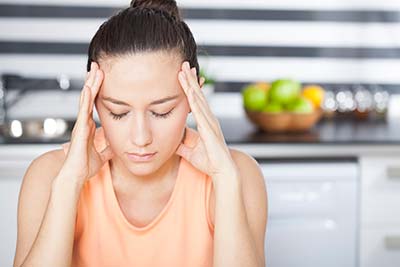 woman suffering from a migraine due to TMJ issues