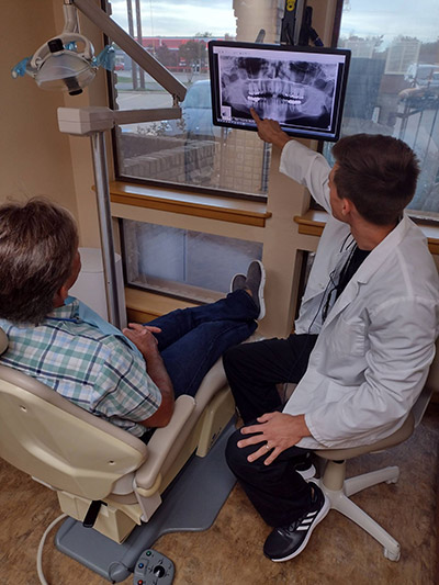 Dr. Beelman showing a patient their x-rays after getting dental implants