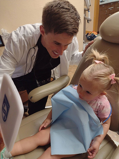 Dr. Beelman smiling with a young patient during her dental appointment