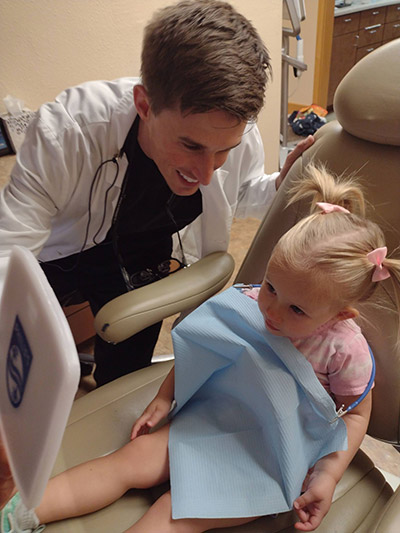 Dr. Beelman smiling with a young patient during her dental appointment at Beelman Dental in Bedford, TX
