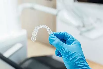 dentist holding a patient's new Invisalign clear aligners